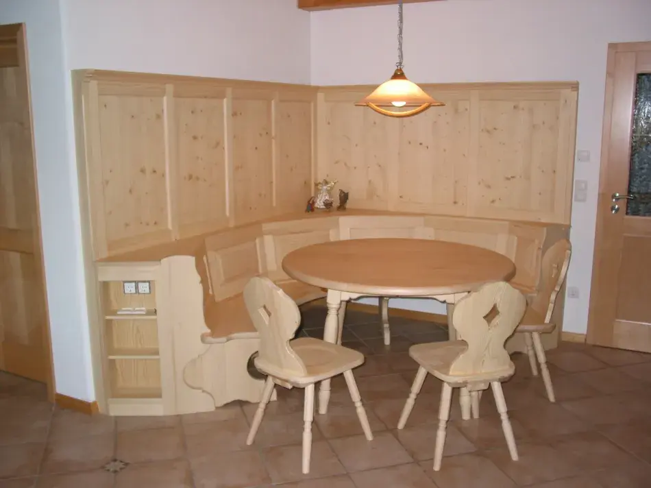 Essplatz mit einer Eckbank mit 2 Stühlen und einem runden Tisch