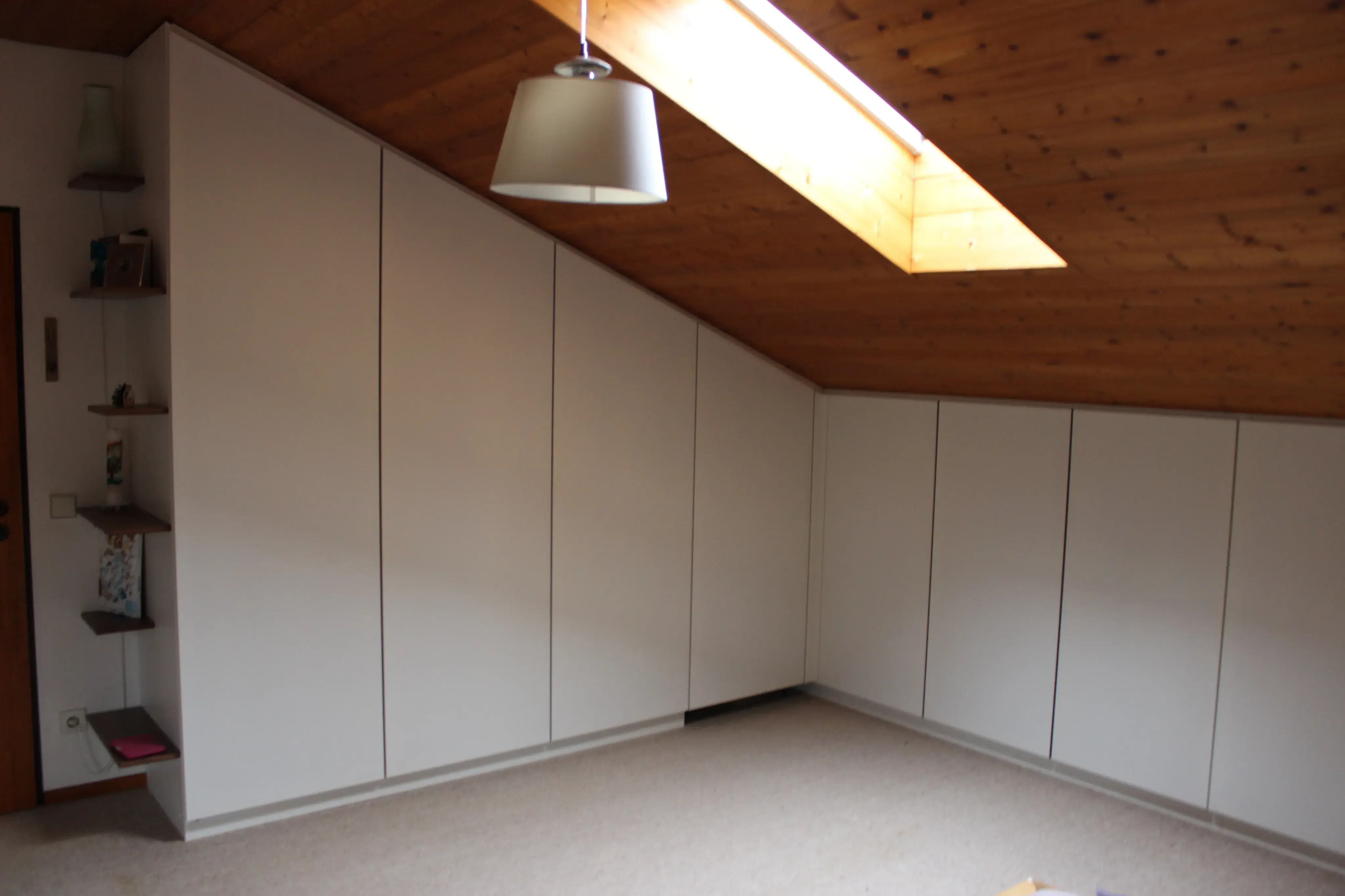 Einbauschrank Oberfläche weiß mit Strukturlack.  Grifflos mit Schattenfuge zur Dachschräge