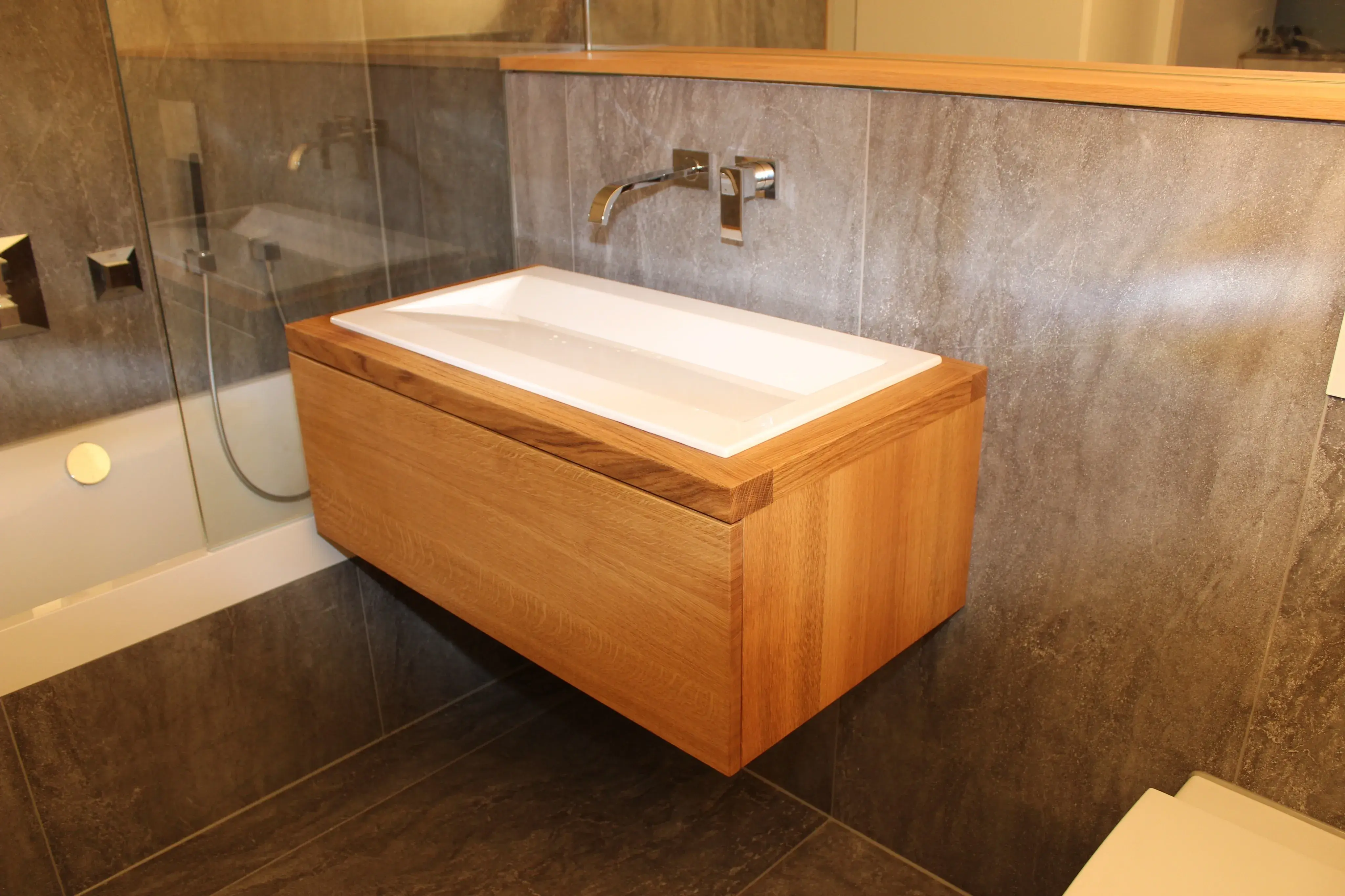 kleines Waschbecken eingepasst neben der Badewanne